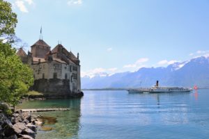 Vue du château depuis la plage située côté Montreux. Un bateau de la CGN approche de la forteresse.